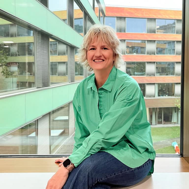 Claudia Becherer sitting at the window with a view of the UKBB